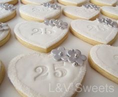 heart shaped cookies decorated with white frosting and silver decorations