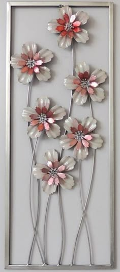 a metal flower wall hanging on the side of a wall in front of a mirror