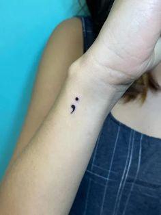 a woman's arm with a small tattoo on it