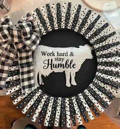 a black and white cow wreath with the words work hard and stay humble on it