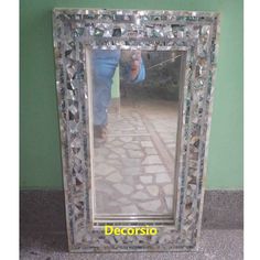 a mirror that is sitting on the ground next to a green wall with a person taking a photo