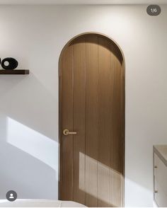 a bedroom with a wooden door and white walls