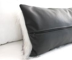 a black leather pillow with white fur on it