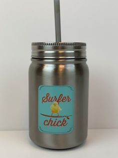 a stainless steel mason jar with a straw in the lid that says,'super chick '