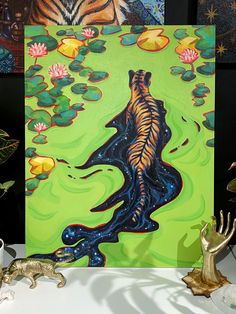 there is a painting on the table with water lilies and a tiger in it