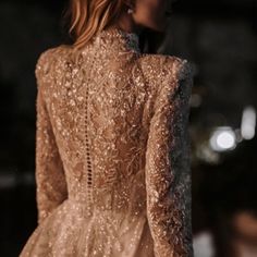 the back of a woman's dress with gold sequins