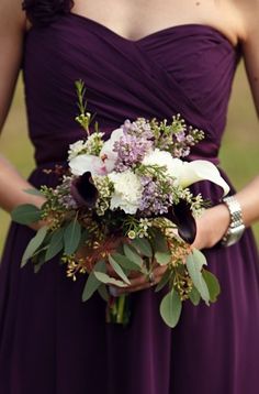 a bridesmaid's bouquet arranged in purple