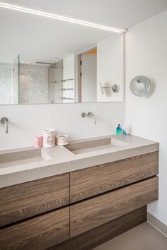 a bathroom with two sinks and a mirror on the wall next to it is shown