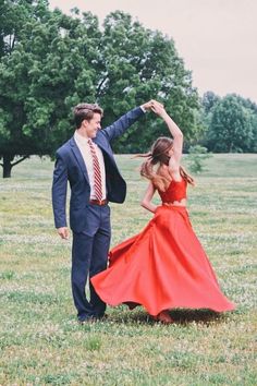 a man and woman dancing in a field