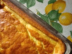 a close up of a cake in a pan with lemons on the table behind it