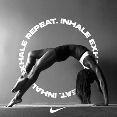 a woman doing a handstand in front of a nike logo