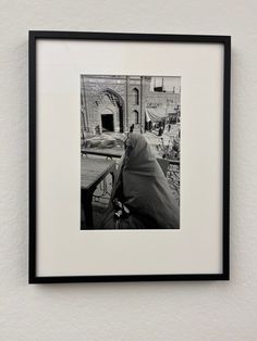 a black and white photo hanging on the wall next to a table with a cloth draped over it