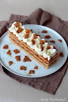 a white plate topped with food on top of a table next to a brown napkin