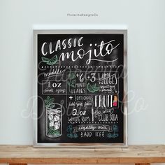 a chalkboard sign with the words classic mojito written on it in front of a wooden table