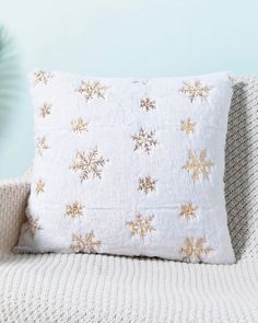 a white pillow with gold snowflakes on it