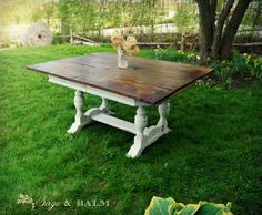 a wooden table sitting on top of a lush green field