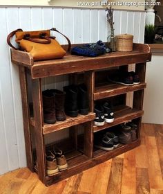 a wooden shelf with several pairs of shoes on it and a handbag hanging from the top