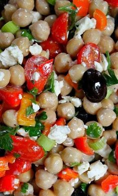 a salad with chickpeas, carrots, tomatoes and feta cheese on it