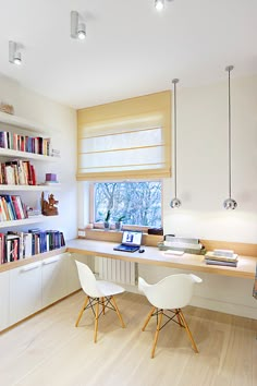 two chairs are sitting at a desk in front of a window with bookshelves