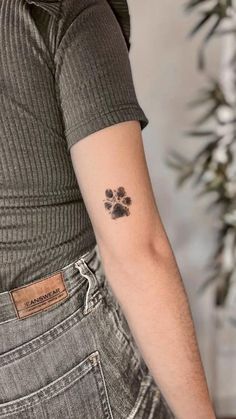 a person with a small paw tattoo on their arm