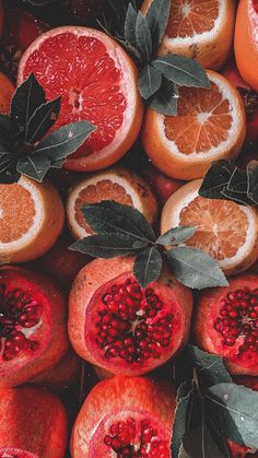 oranges and pomegranates with leaves on them