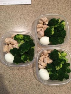 three plastic containers filled with broccoli and chicken next to an egg on the counter