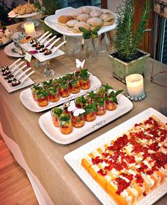 a table topped with lots of food on top of white plates next to each other