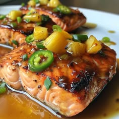 two grilled salmons with pineapple and jalapenos on a white plate