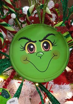 a close up of a green frisbee on a christmas tree with red and white ornaments