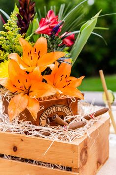 an orange flower arrangement in a wooden box