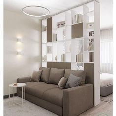 a living room filled with furniture and bookshelves in front of a white wall