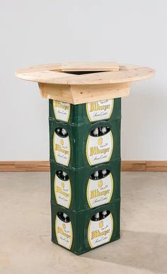 four beer bottles stacked on top of each other in front of a round wooden table