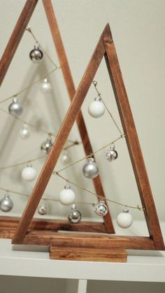 two wooden christmas trees with ornaments on them