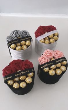 four round boxes with roses and chocolates in them