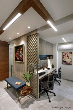 an office with a desk, chair and painting on the wall in it's corner