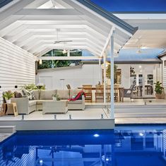 an outdoor living area next to a swimming pool