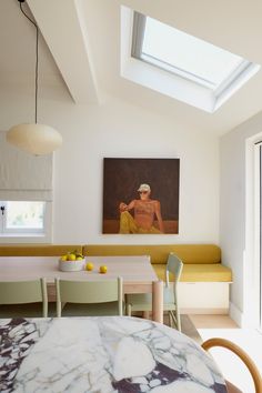 a dining room table with chairs and a painting on the wall in the back ground