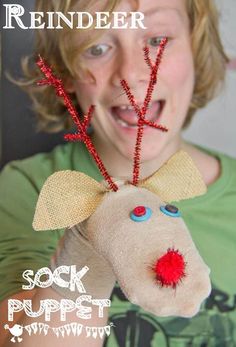 a young boy holding a stuffed animal with red antlers on it's head