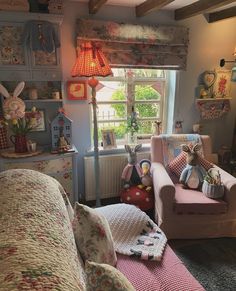 a living room filled with lots of furniture next to a window and a lamp on top of a table