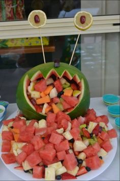 watermelon, apples, and grapes are arranged on a plate