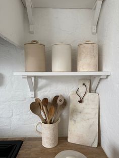 a kitchen shelf with pots, pans and utensils on it