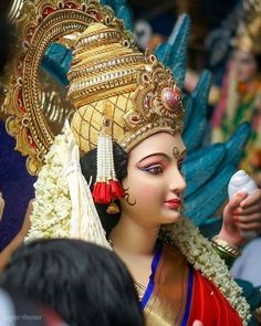 a close up of a statue of a woman wearing a headdress and holding a bottle