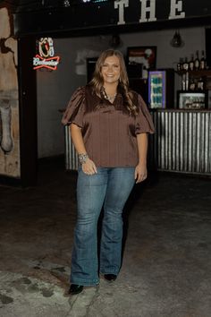 This plus-size Collar, V-Neck, Puff Sleeve Top in a warm brown tone brings a Western-inspired flair to your wardrobe. The flattering V-neckline is accented by a classic collar, while the puff sleeves add a touch of femininity and volume. The rich brown color complements Western accessories like statement belts and cowboy boots, making it a versatile piece that can be dressed up for rodeo nights or styled casually with denim for everyday wear. Anna is wearing a size 3X. We suggest sizing up if bu Statement Belts, Short Jean Skirt, Cc Beanie, Western Accessories, Brown Tone, Color Complement, Boutique Homes, Warm Brown, Puff Sleeve Top