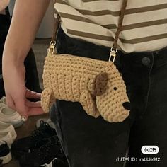 a person holding a crocheted purse with a dog on it