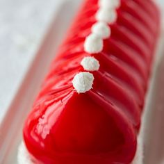 a red and white cake with marshmallows sitting on top of it's side