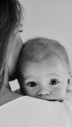 a woman is holding a baby in her arms and looking at it's face