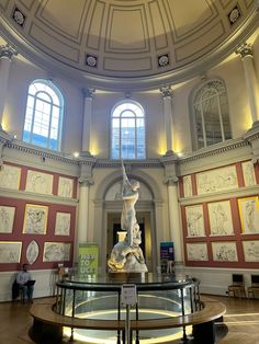 the inside of a building with many paintings on the walls and ceiling, including a statue