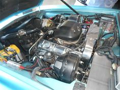 the engine compartment of a blue car with its hood up