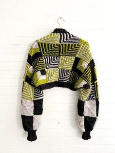 a green and black sweater hanging on a wall