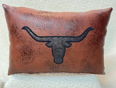 a leather pillow with a longhorn head on it